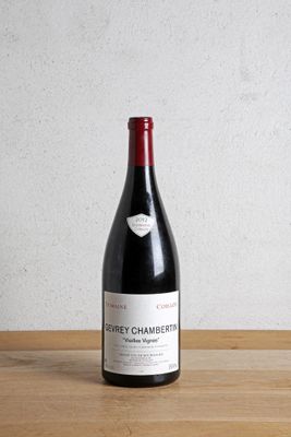 la bouteille de vin rouge est posée sur une table en bois