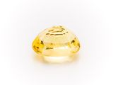 a yellow sapphire stone on a white background