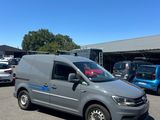 La camionnette grise est garée sur un parking avec d'autres voitures.