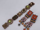 two pieces of jewelry sitting on top of a table next to each other