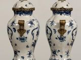 pair of blue and white vases with gold handles on a table