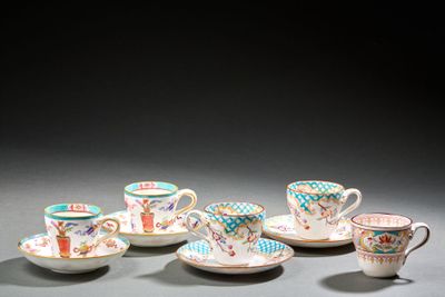 Plusieurs tasses et soucoupes sont alignées sur une table