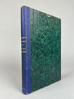 un livre bleu et vert posé sur une table blanche