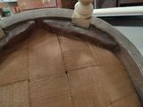 a small wooden figure sitting on top of a wooden barrel