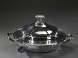 une cocotte ancienne en métal argenté avec un couvercle en verre