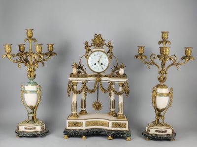 three antique clocks and a clock stand in a row on a gray background