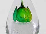 a glass vase with a green flower inside of it