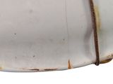 a white plate with a rusted handle on it