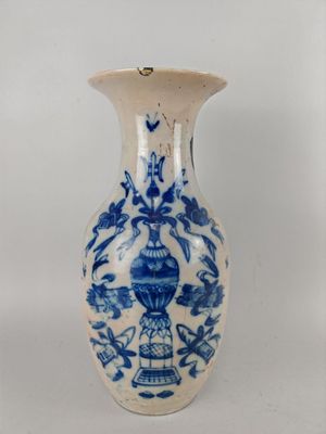 un vase bleu et blanc posé sur une surface blanche