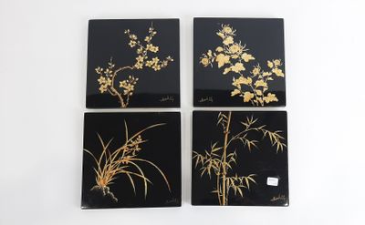 quatre sous-verres noirs et dorés ornés de fleurs et de feuilles