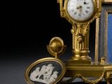 une horloge en or posée à côté d'une photo d'un homme