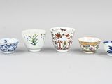 quatre types différents de tasses et de soucoupes posées sur une table