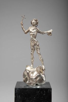 une statue en argent représentant une femme tenant une baguette magique, posée sur un socle en marbre