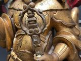 a gold statue of a person holding a ball