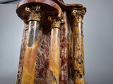 three marble columns with gold and red marbles on them