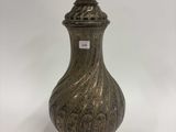 une photo d'un vase argenté posé sur une table blanche