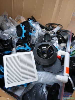une boîte en carton contenant divers objets, notamment un ventilateur et un ventilateur de refroidissement