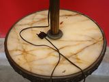 an image of a table with a lamp on it and a red wall in the background