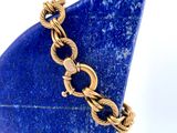 bracelet plaqué or orné d'une pierre bleue sur fond blanc