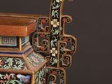 an image of a decorative vase with a wooden stand on a black background