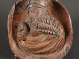 un gros plan sur une sculpture en bois représentant un homme barbu