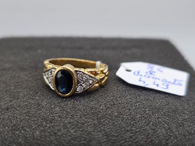 Gros plan sur une bague en or ornée d'une pierre bleue