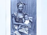 a black and white photo of a woman holding a baby