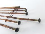 several old canes are lined up on a white surface