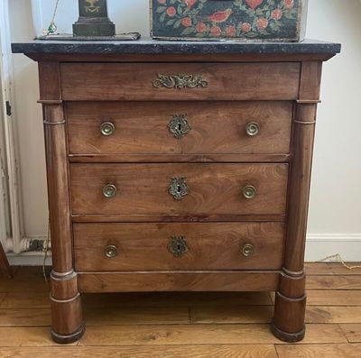 une commode en bois surmontée d'une horloge