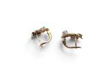 a pair of gold earrings with a bird ' s head on them