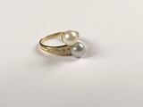 a close up of a gold ring with two pearls on it