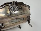 a silver box with a handle on a white surface