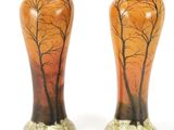 two vases with trees painted on them sitting on a white surface