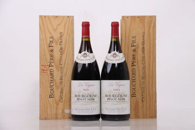 two bottles of red wine sit next to a wooden box