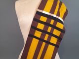yellow and brown striped scarf on a mannequin torso