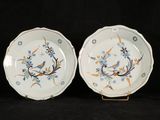 two plates with blue and orange designs on them on a black background