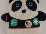 stuffed panda bear wearing a black and white jacket with lots of buttons on it