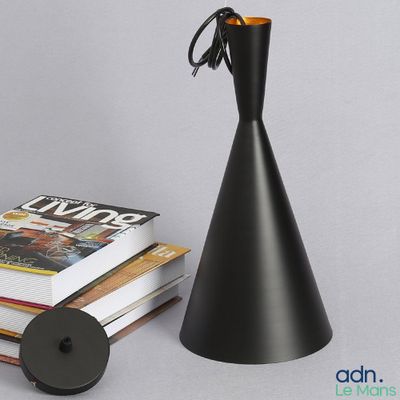 une lampe noire posée à côté d'une pile de livres