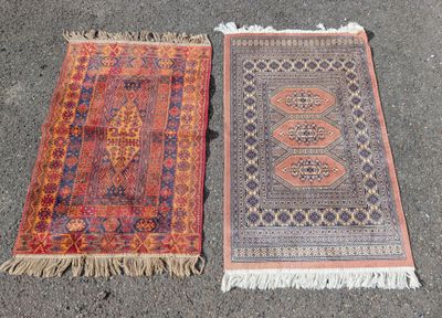 deux tapis orientaux posés à même le sol, ornés de franges