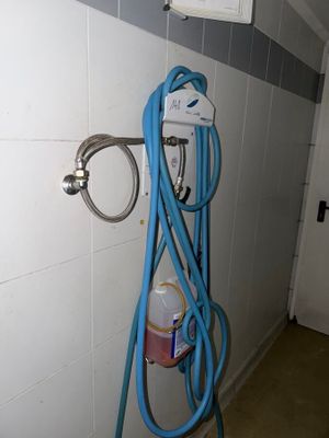 a blue hose attached to a wall in a bathroom