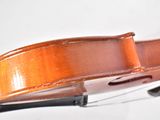 a violin that is sitting on a white surface