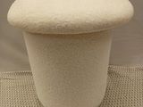 tabouret recouvert de laine blanche, avec un piètement blanc, sur fond blanc