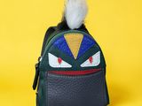 a close up of a small bag with a furry ball on it