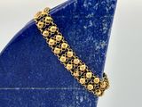 un gros plan d'un bracelet en or orné d'une pierre bleue