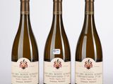 trois bouteilles de vin posées l'une à côté de l'autre sur une table