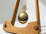 a wooden pendulum clock with a pendulum hanging from it ' s side