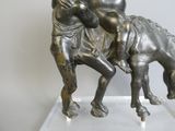 une statue représentant un homme à cheval avec un enfant sur le dos