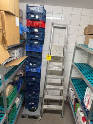 une échelle au milieu d'une pièce, sur laquelle sont posées de nombreuses boîtes