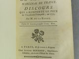 un livre ouvert posé sur une table à côté d'une tasse de café