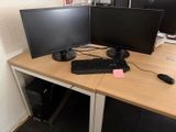 un bureau sur lequel sont posés deux écrans d'ordinateur et un clavier